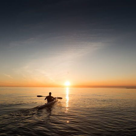 Homme kayak de mer coucher de soleil
